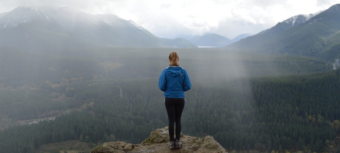 Woman overlooking a valley of trees